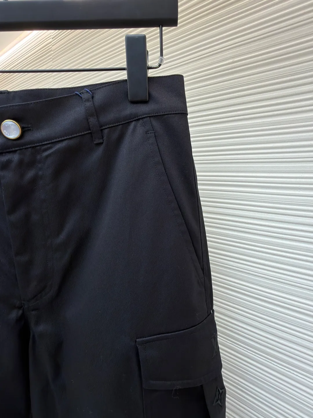 LOUIS VUITTON pocket embroidered work trousers ●Original version: Purchased and developed by 12324 ●Item number: 1682341-B50 ●Fabric: cotton twill fabric ●Technology: embroidery production ●Color: black ●Version: fitted version ●Weight: about 535 grams ●Size: 44-46-48-50 ●Description: The high cotton content ensures the fabric's excellent breathability, durability and classic workwear texture, while the twill weave gives it unique wear resistance and stiffness. The special fabric technology solves the pain points of tight and stiff traditional overalls; it provides greater freedom when moving, significantly improves wearing comfort and flexibility, and achieves a balance between function and comfort. The application of three-dimensional core-spinning embroidery technology in the pocket position is achieved by adding additional cotton thread or foam as the core material to the pattern filling layer, and then using embroidery thread to fully cover the embroidery. The logo pattern is significantly protruded from the surface of the fabric, forming a full three-dimensional effect. This process not only enhances the visual impact and tactile level, but also improves the wear resistance of the pocket area through the buffering effect of the core material, ensuring that the pattern can still remain crisp and not deformed in complex daily use, ensuring that the pattern is clear and durable, and injecting a sense of sophistication into the rugged workwear style. Diversified pocket system combines workwear functionality with sophistication. The flap cargo pockets on both sides are a signature element, and their flap design prevents items from falling and enhances the visual three-dimensionality. Italian style pockets provide simple side storage. The overall wiring is straight and delicate, the fabric is comfortable and soft, and the color is consistent without color difference. It can be matched with the same style to create a fashionable look and control various occasions. Customized accessories, complete with three standards, same style for men and women!